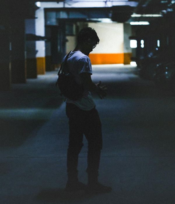 Silhouette of a person in quiet contemplation against a dark background.